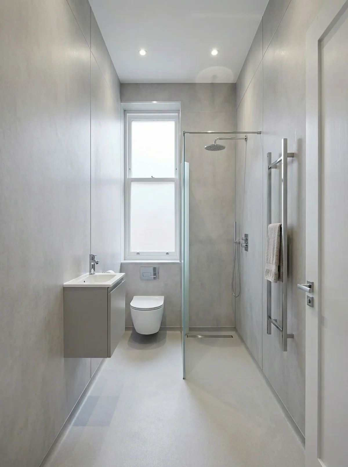 Compact bathroom with a slim vanity and walk-in shower beside a tall window